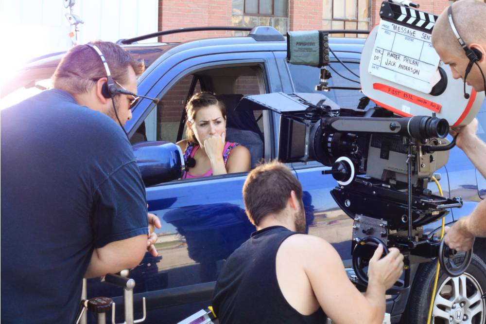 A camera team shooting a women in a car